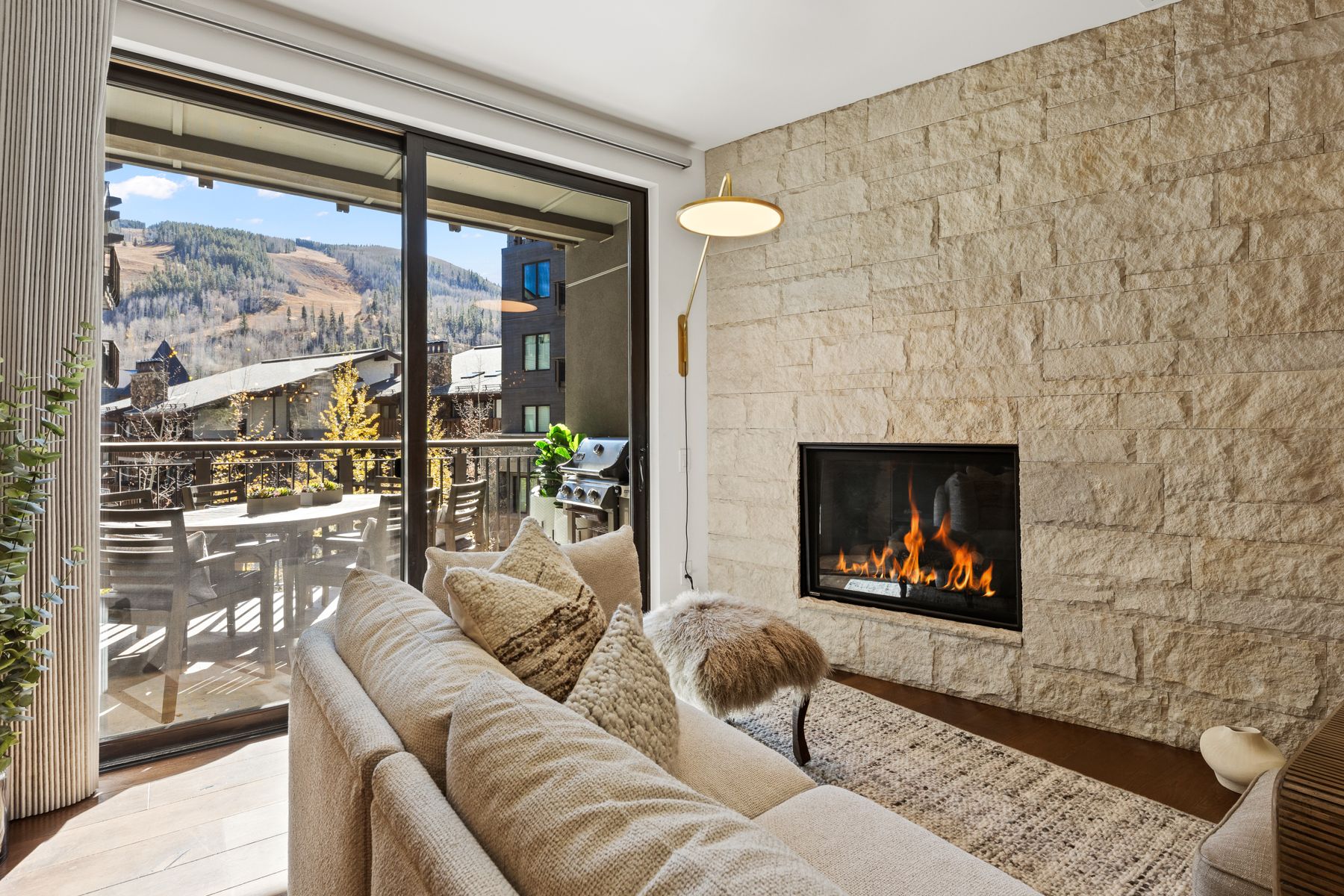 Living room with stone fireplace and balcony